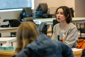 Student at desk speaking.