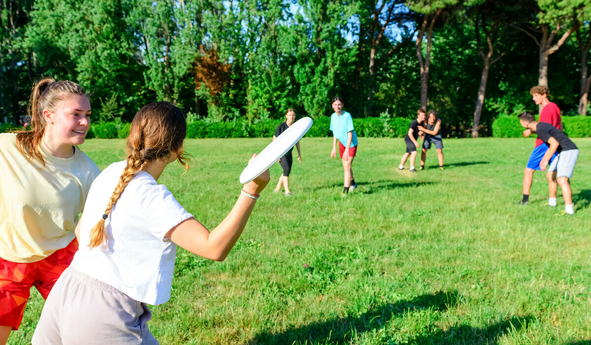 Students playing frisbee on a grassy field.